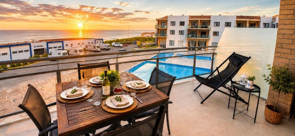 a table on a balcony with a view of the ocean at Like-Home-T1-Sun & Beach-Pools, AC in Ericeira