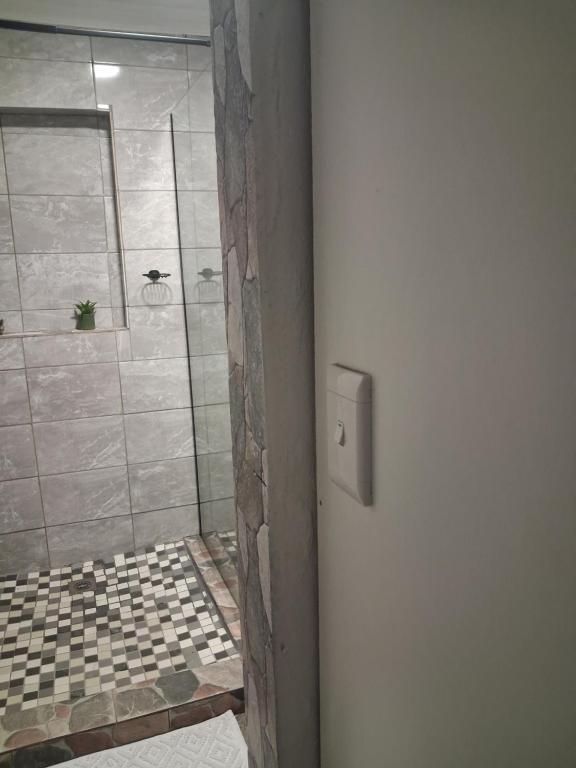 a bathroom with a shower with a tiled floor at Trendy Tranquility in Secunda