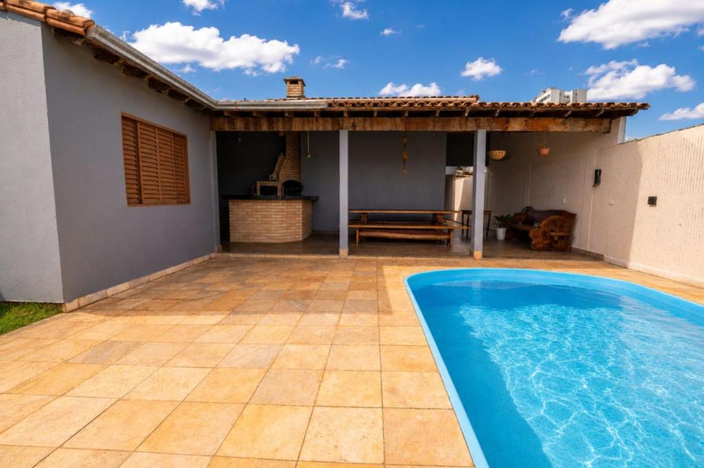 a swimming pool in front of a house at Casa com Piscina Aquecida e Churras em Uberlândia in Uberlândia