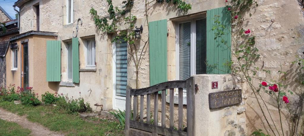 an old building with a gate and a green door at Gîte des petits givrés in Entrains-sur-Nohain