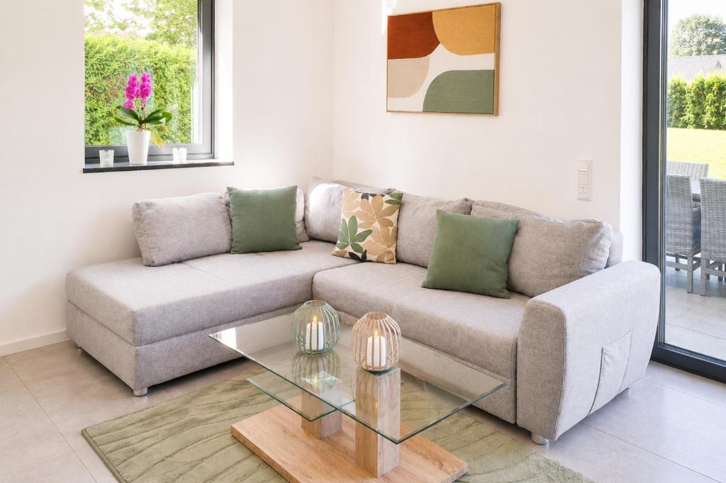 a living room with a couch and a glass table at Moderne Ferienwohnung,im fränkischen Seenland , 25 min Messe Nbg in Roth