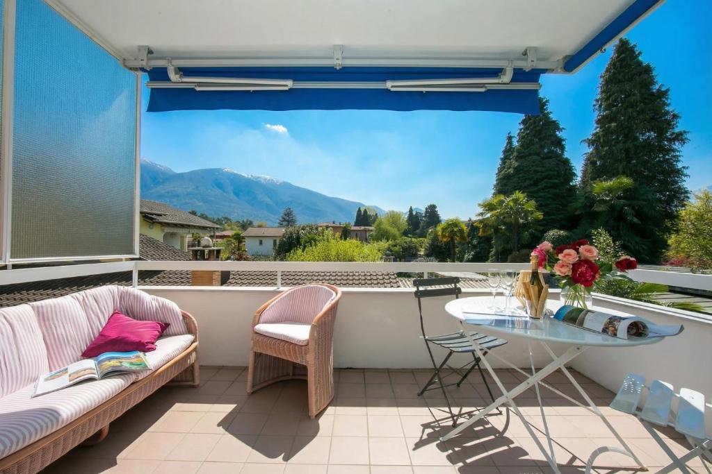 a patio with a table and a view of a mountain at Charm Apartment with Balcony and Parking - Happy Rentals in Ascona