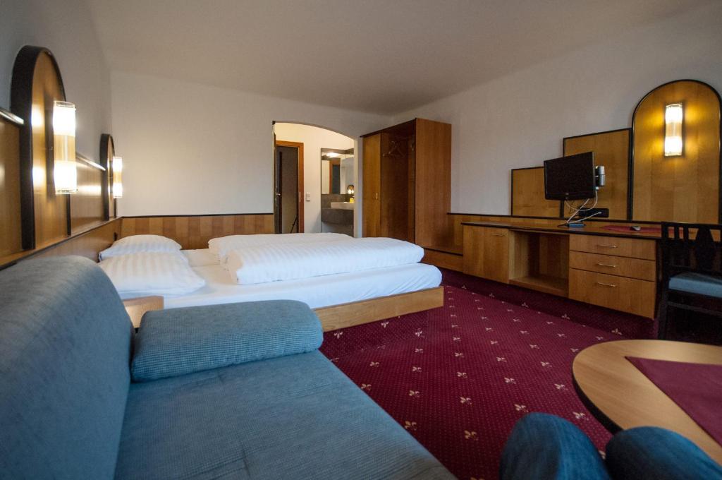 a hotel room with two beds and a couch at Hotel Gasthof Sonne in Aschach an der Donau