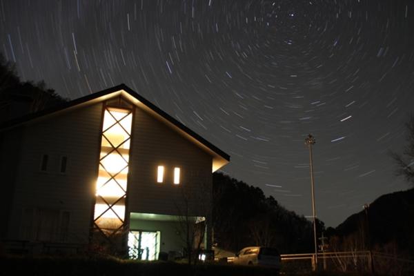 een schuur met een verlicht raam 's nachts bij Hill Top in Kiso