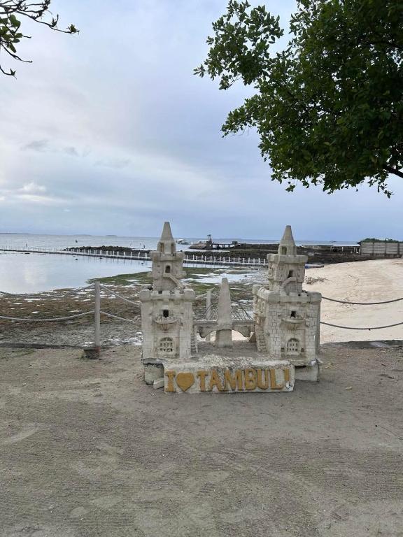 a sand castle sitting on the beach near the ocean at Go Q Tambuli Seaside Studio in Maribago