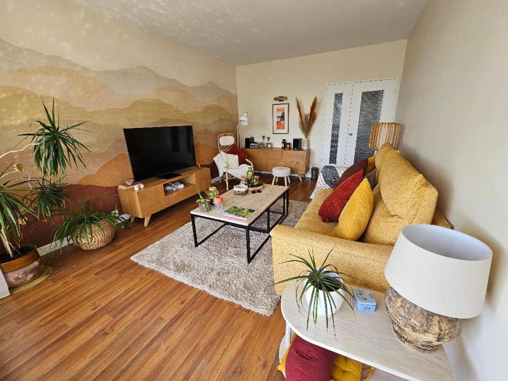 a living room with a couch and a tv at Jasmin Doux in Poitiers