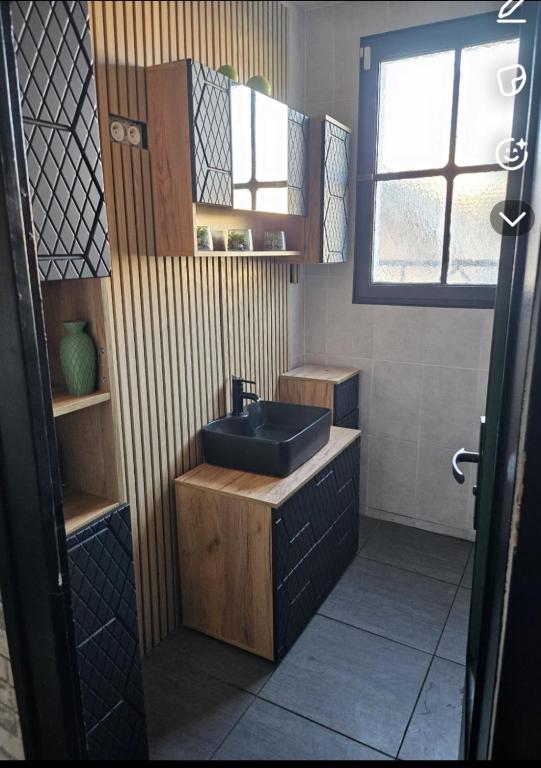 a bathroom with a blue sink and a window at La coconing in Vierzon