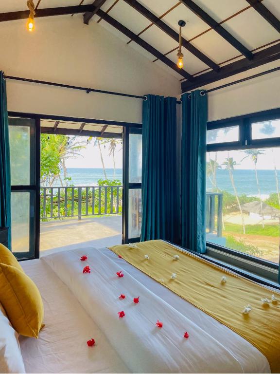a bedroom with a bed with a view of the ocean at Turtle Breeze Rekawa in Tangalle