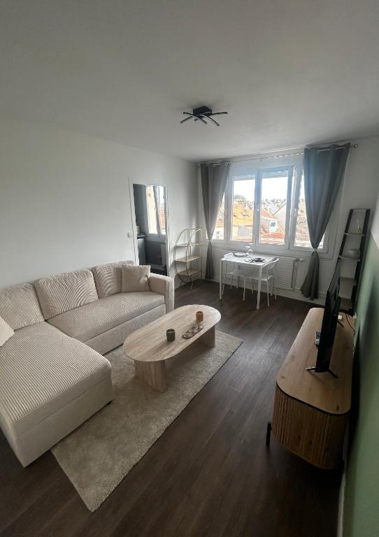 a living room with a couch and a coffee table at Charmant T2 cosy au cœur de Caen Parking gratuit et arrivée autonome in Caen