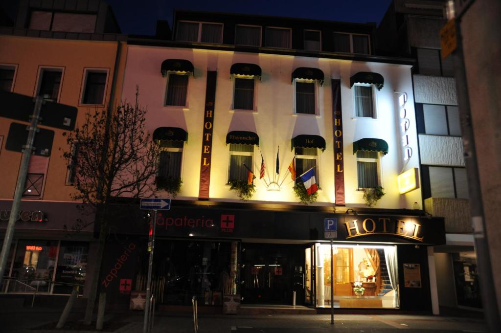 un edificio iluminado con una tienda en una calle en Hotel Rheinischer Hof, en Erkelenz