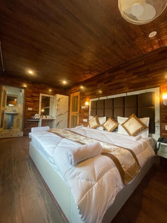 a large bed in a room with a wooden ceiling at The Mountain Suites in Batakūt
