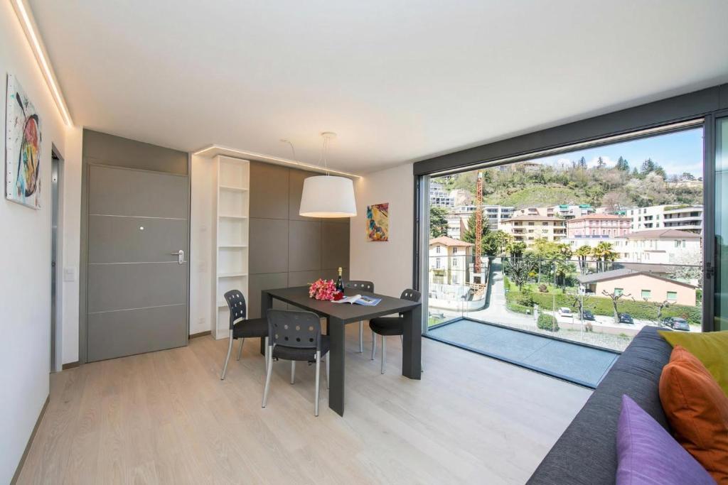 a bedroom with a dining room table and a large window at Urban Apartment Paradiso with Balcony and Parking - Happy Rentals in Paradiso