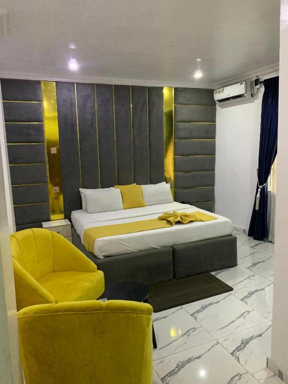 a bedroom with a bed and a yellow chair at Perch Hotel & Suites in Lagos