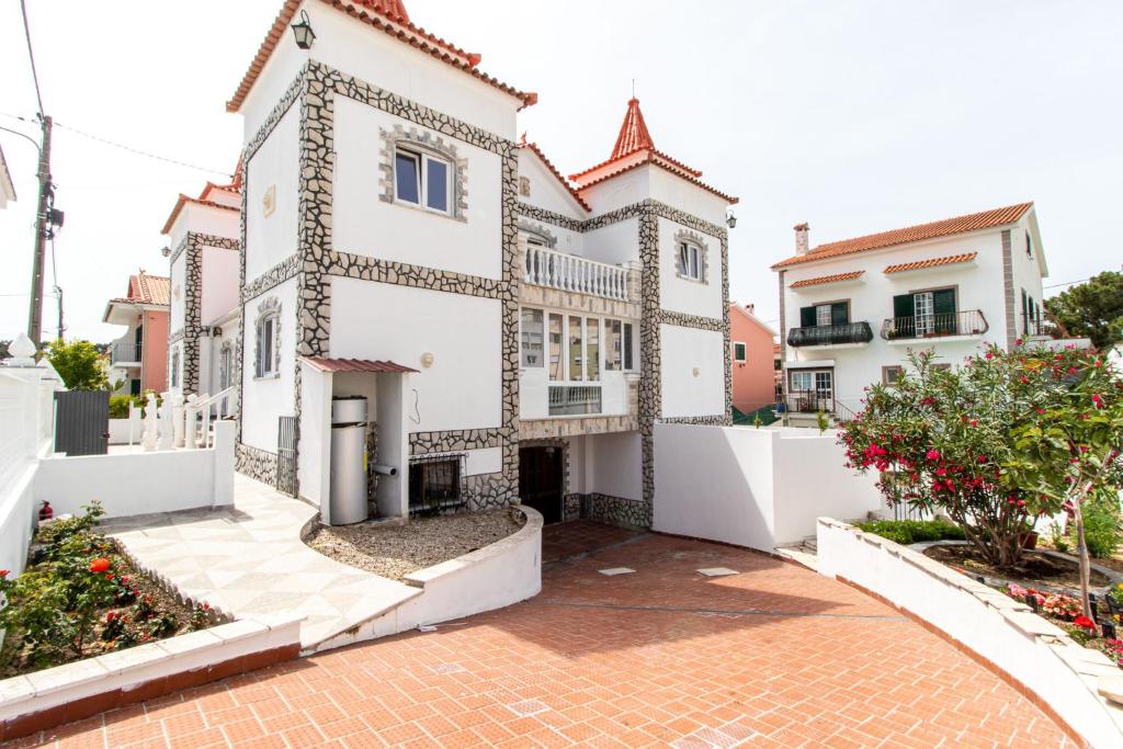 a large white house with a brick driveway at Castelo Sereno in Quinta do Conde