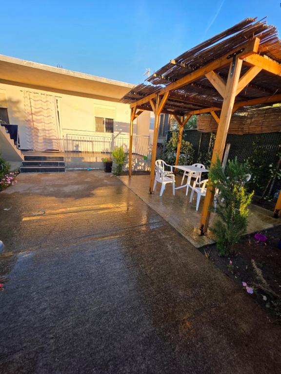 a patio with a table and chairs under a wooden pergola at Vila Eriona in Baks-Rrjoll