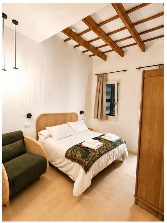 a bedroom with a bed and a chair at Hotelet Bastio 12 in Ciutadella