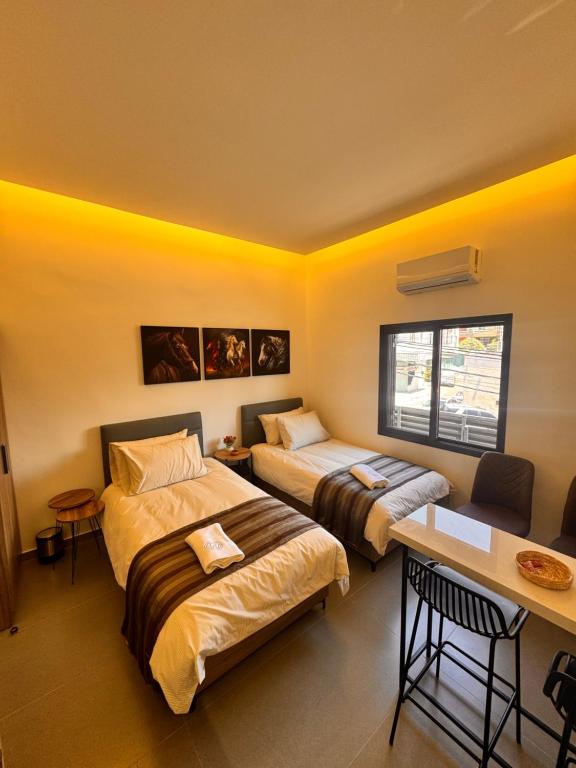 a hotel room with two beds and a desk at Railway Studio 1 - Cozy Studio in Byblos - Central Location in Jbeil