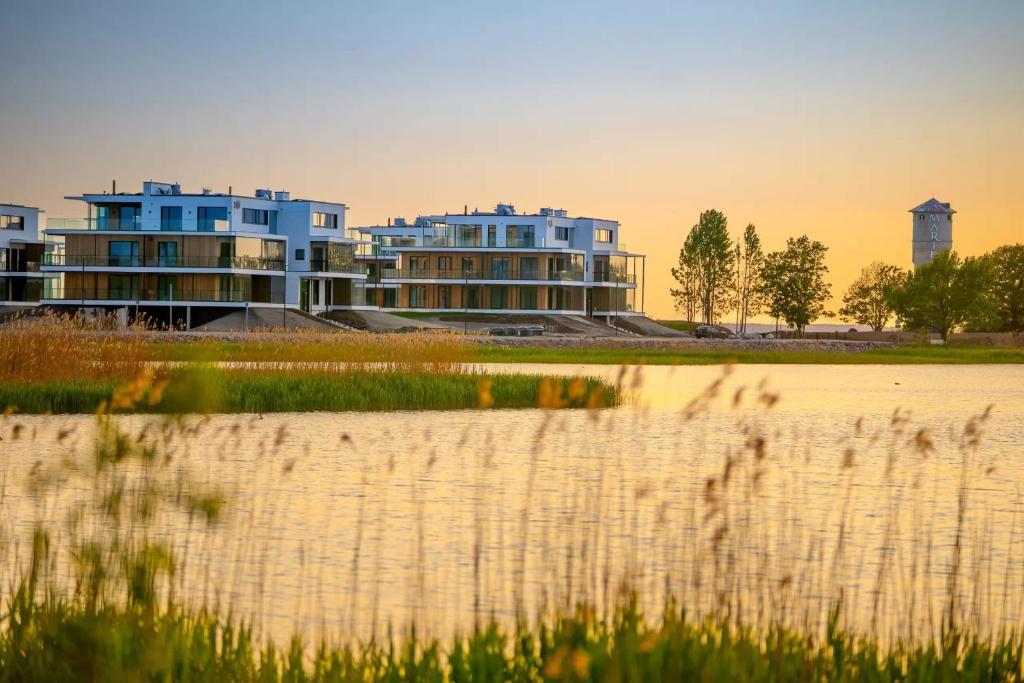 a group of houses in front of a body of water at MarienHome Loojangu in Haapsalu