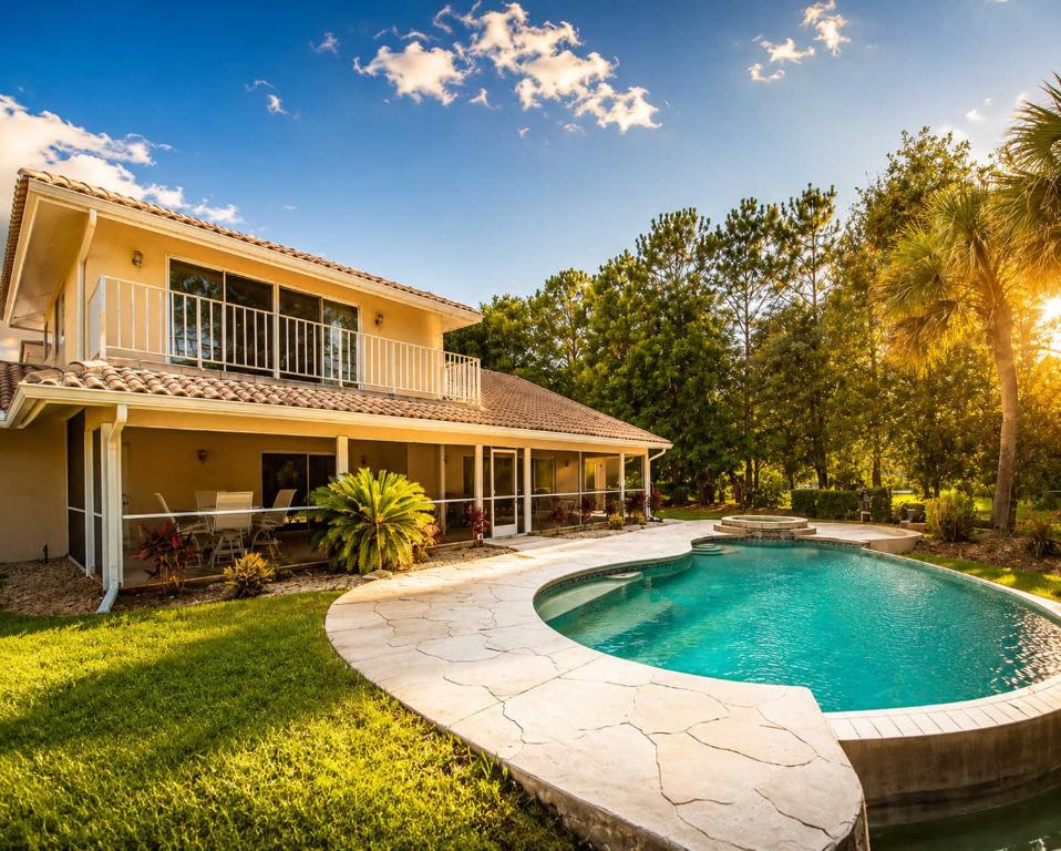 a house with a swimming pool in front of a house at SWISS 41 - Golf Course in Clermont