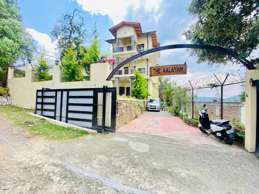 a house with a motorcycle parked in front of a garage at The Aalayam in Mukteshwar