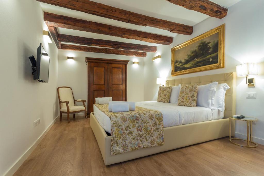 una camera con un letto bianco e una sedia di Home Venice Apartments-Rialto 1 - 2 - 3 a Venezia