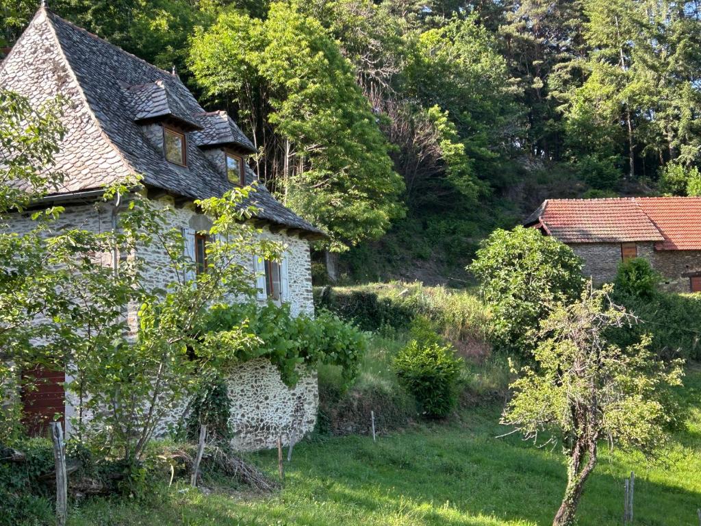 an old house in the middle of a field at L'Oustalou de Petit Jean in Cassaniouze