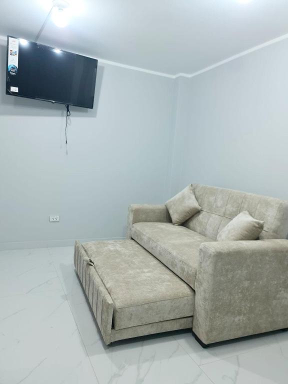 a living room with a couch and a flat screen tv at Montecarlo Hospedaje in Tacna