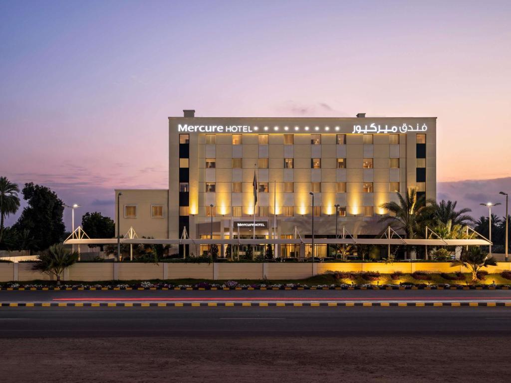a hotel with a sign on the side of a building at Mercure Sohar in Sohar