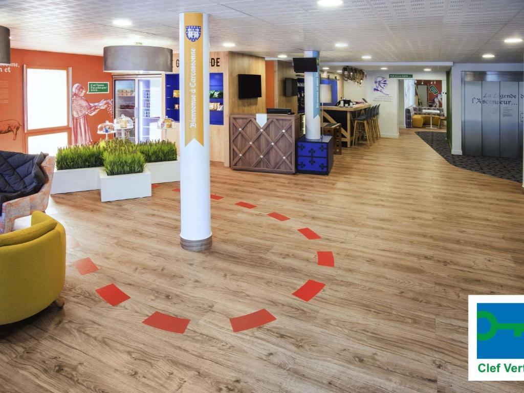 a lobby with a floor with red squares on it at ibis Styles Carcassonne La Cité in Carcassonne