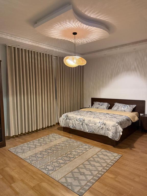ein Schlafzimmer mit einem Bett und einem Kronleuchter in der Unterkunft شقة غيم in Abha