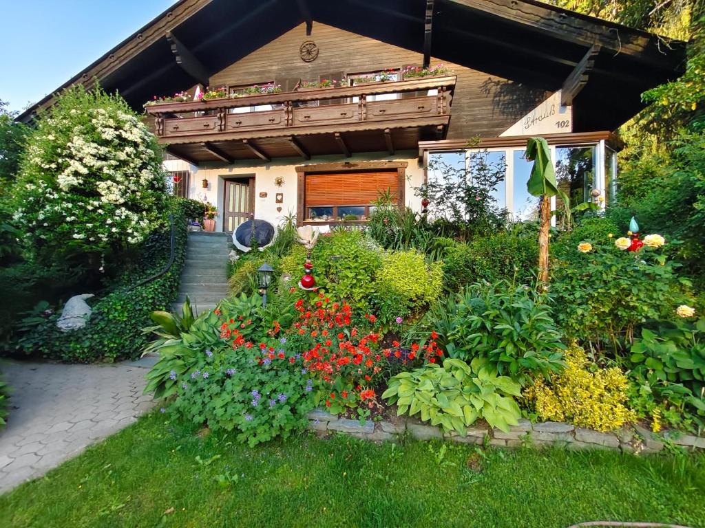 a garden in front of a house with flowers at Blumenpension Strauss - Ferienwohnungen in Ossiach