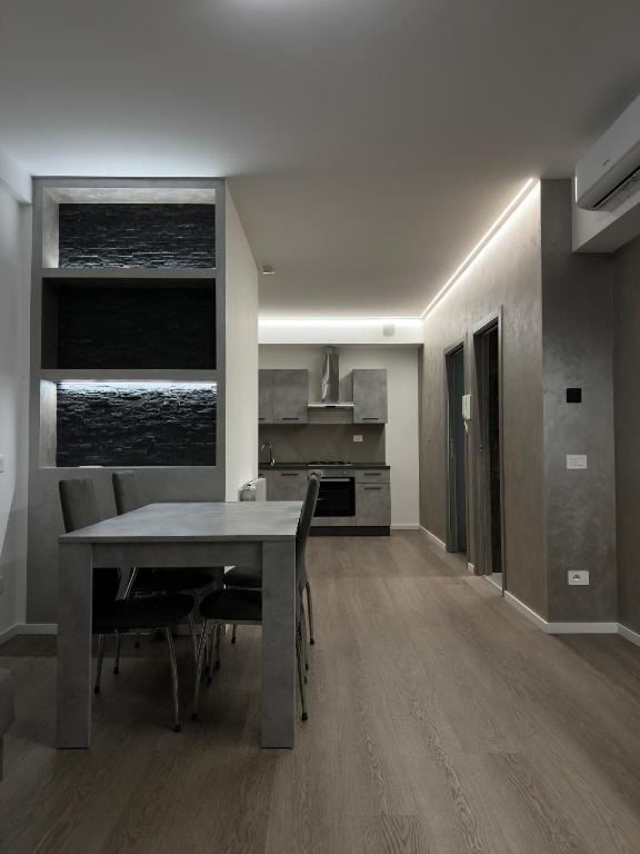 a kitchen and dining room with a table and chairs at Grey loft in Torvaianica