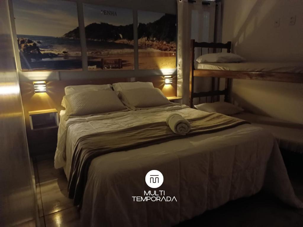 a bedroom with a bed with a hat on it at Pousada Família Cordeiro - Penha/SC in Penha