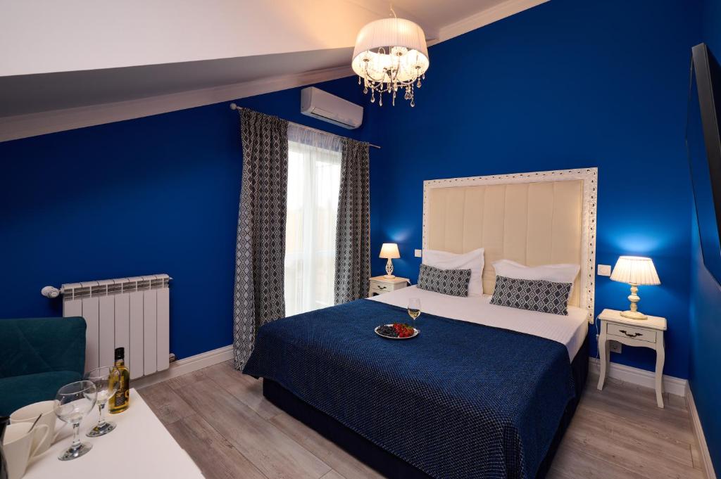a blue bedroom with a bed and a blue wall at REGINA Bed&Wine in Varna City
