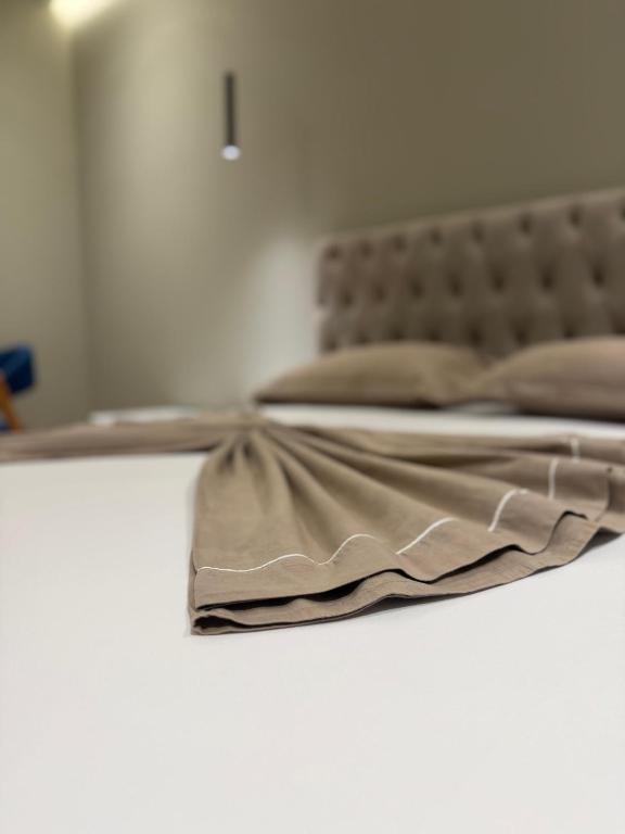 a bedroom with a bed with a brown bedspread at Gysi`s Hotel & Restaurant - Near Tirana in Tapizë