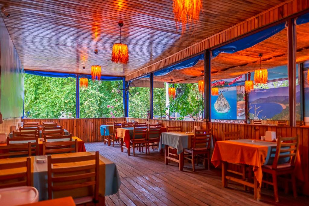 a dining room with tables and chairs and lights at Adrasan Çıtır Pansiyon in Kumluca