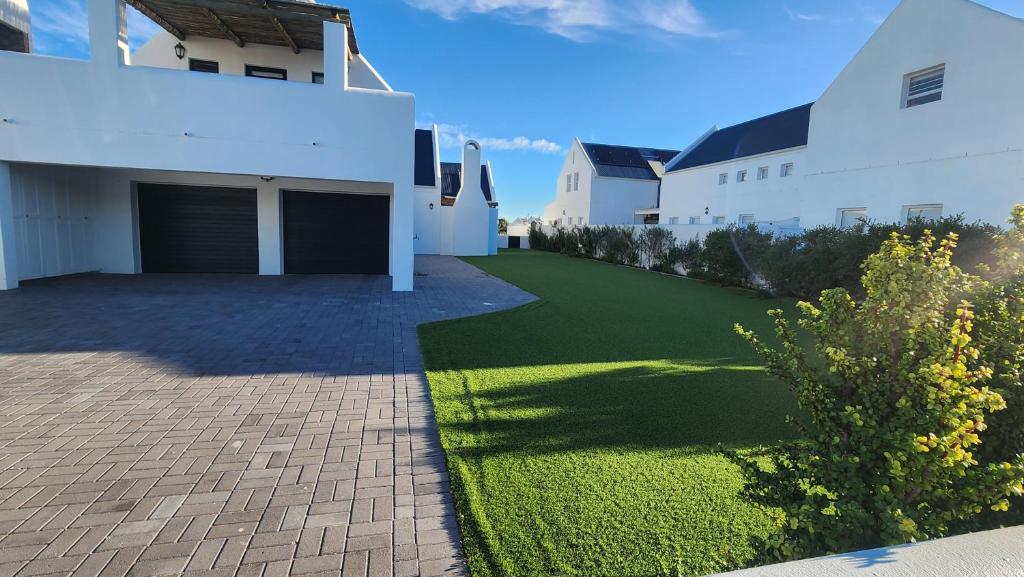 a house with a driveway and a grass yard at Apollo on Sea in Velddrif