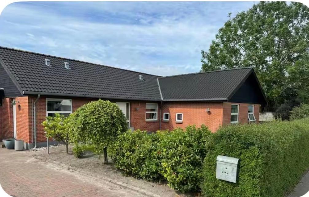 a red brick house with a black roof at Cozy house in Hasseris in Aalborg