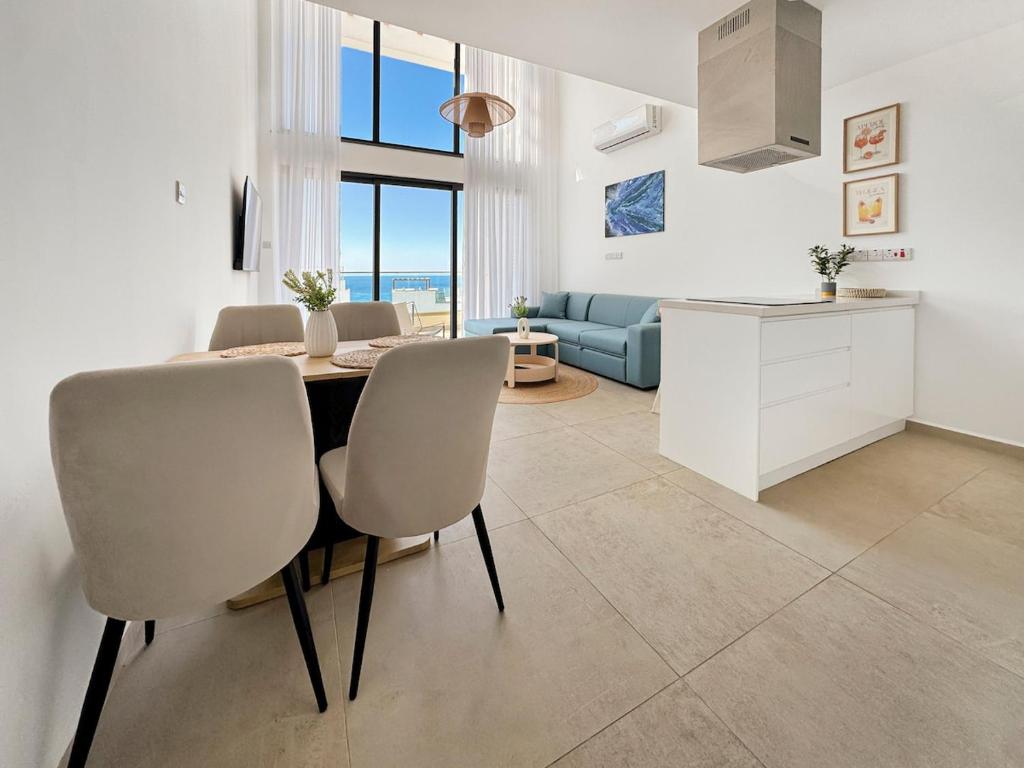 a kitchen and living room with a table and chairs at LUKA Duplex SeaView and Terrace in Aglantzia