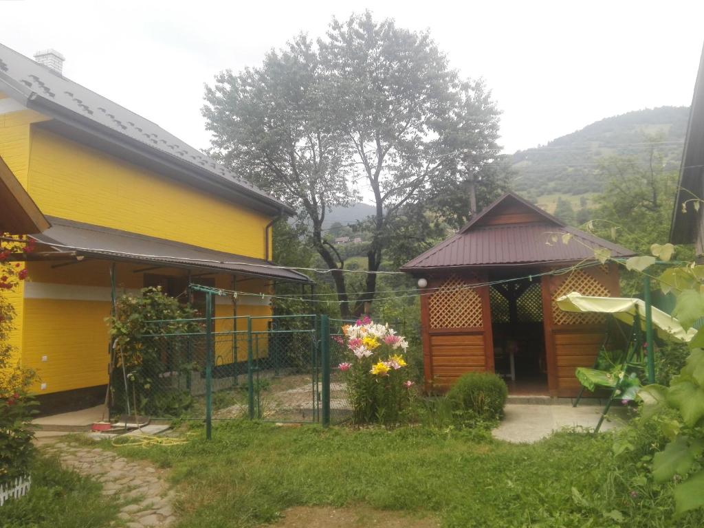 a yellow house with a fence in front of it at Вікенд WeekEnd in Kvasy