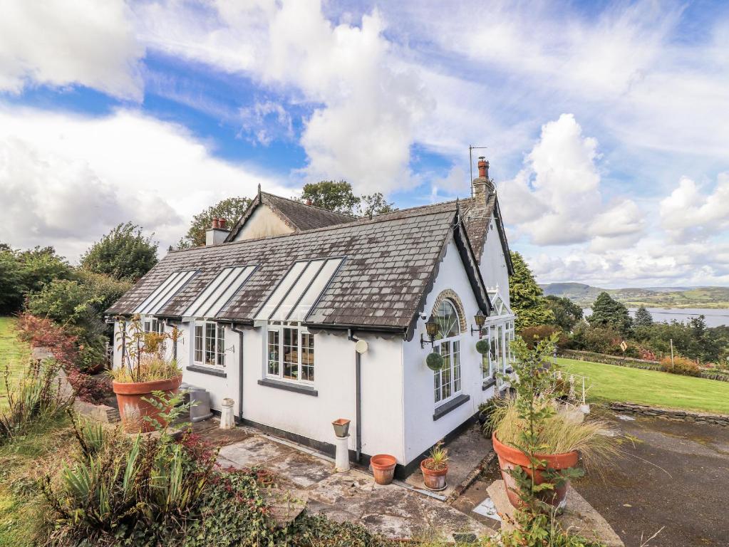 a small white house with plants in front of it at White Heather Cottage in Killaloe