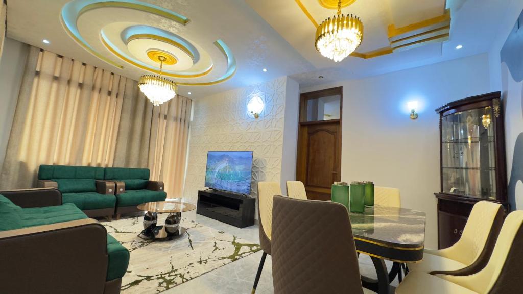 a living room with a green couch and a table at Etoile de Nathalice in Kinshasa