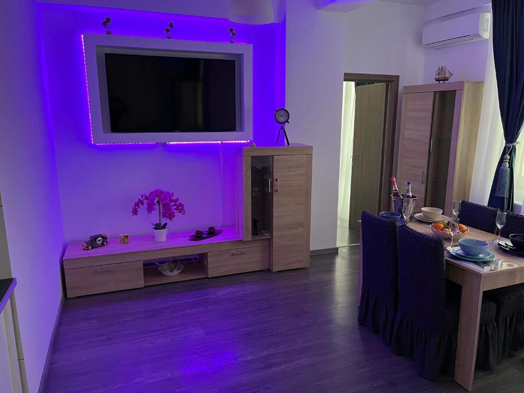 a living room with a tv and purple lighting at The Lighthouse Suite in Mamaia Sat/Năvodari