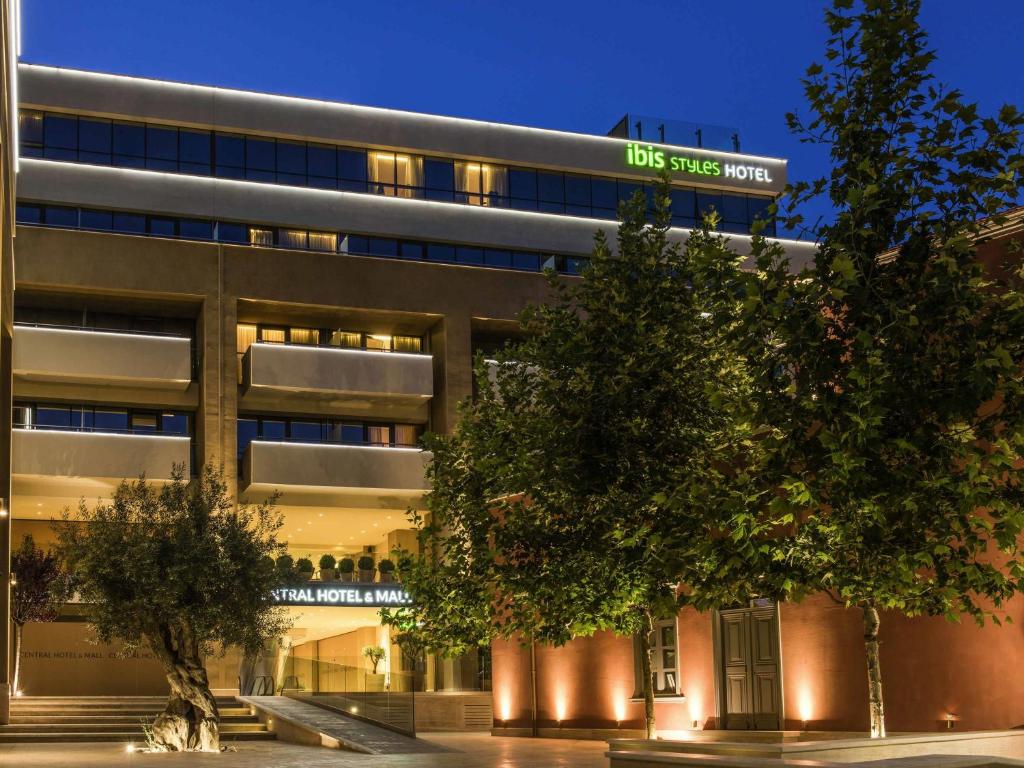 a building with trees in front of it at Ibis Styles Heraklion Central in Heraklio