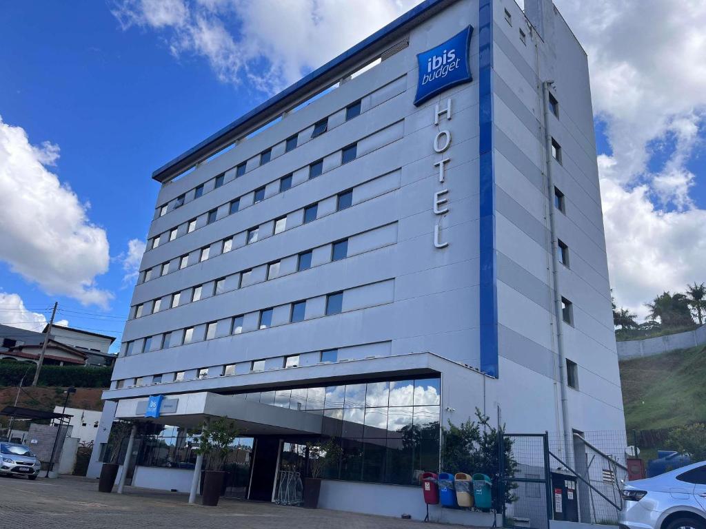 a large white building with a sign on it at ibis budget Manhuaçu in Manhuaçu