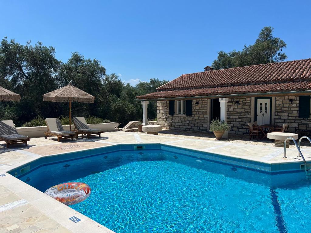 a swimming pool in front of a house at Villa Delphini in Argyrátika