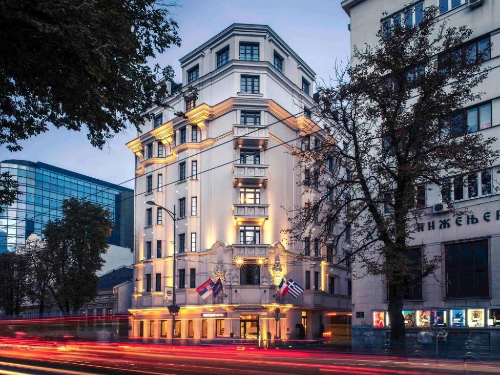 a tall white building on a city street at Mercure Belgrade Excelsior in Belgrade