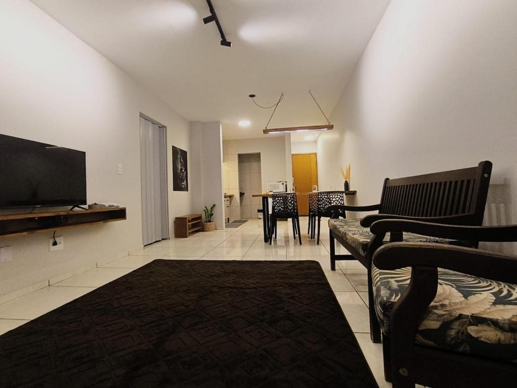 a living room with a flat screen tv and a couch at Apartamento 11 - 2 Quartos com AC e cama de casal in Toledo