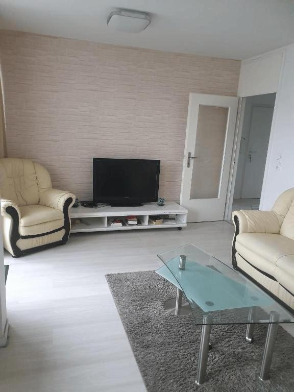 a living room with two chairs and a flat screen tv at Messewohnung-Monteurwohnung Dormagen in Dormagen