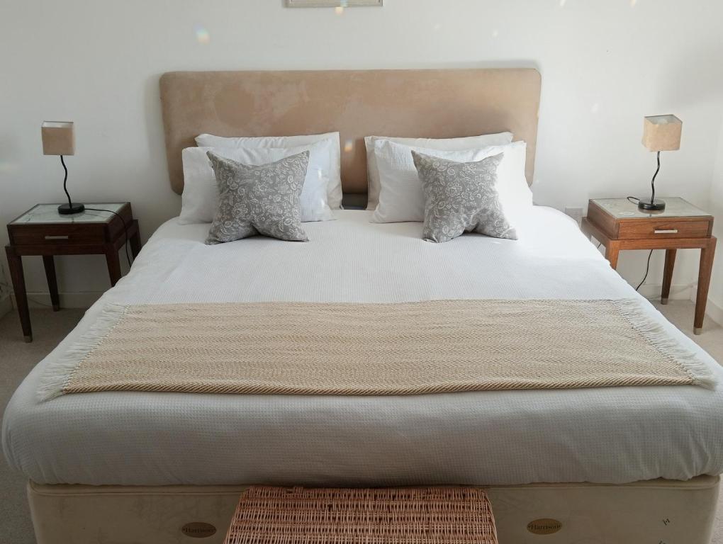 a large bed with white sheets and pillows at Little Paradise Marlborough in Marlborough